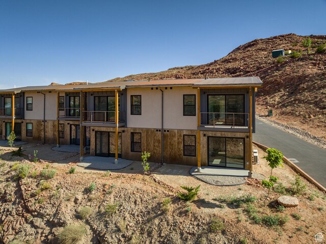 1185 S Murphy Ln Unit 106B, Moab, UT 84532 - back of property with a balcony, a patio, a mountain view, and stucco siding