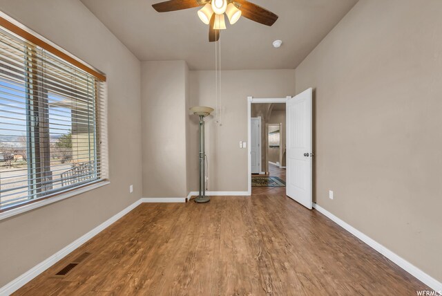 unfurnished bedroom featuring ceiling fan and dark wood-type flooring