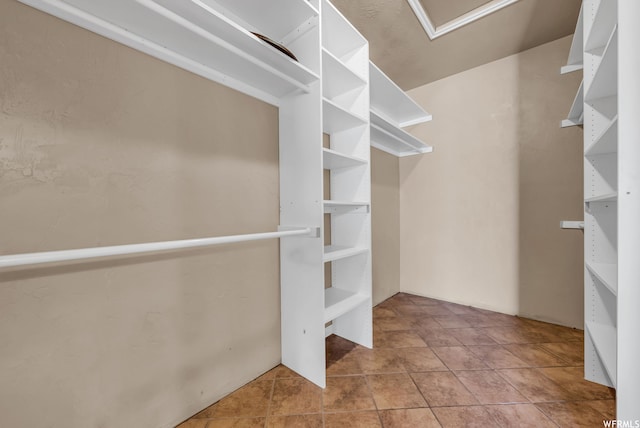 walk in closet with light tile floors