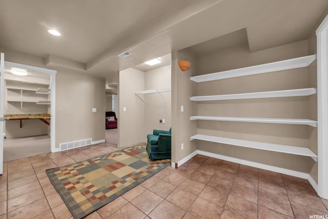 walk in closet with light colored carpet
