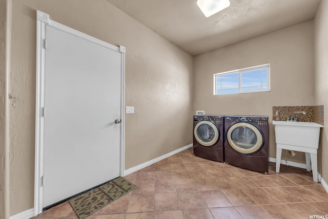 clothes washing area featuring light tile floors and washing machine and clothes dryer