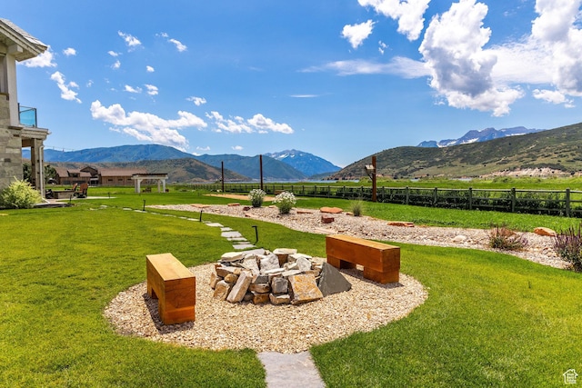 view of yard with an outdoor fire pit and a mountain view
