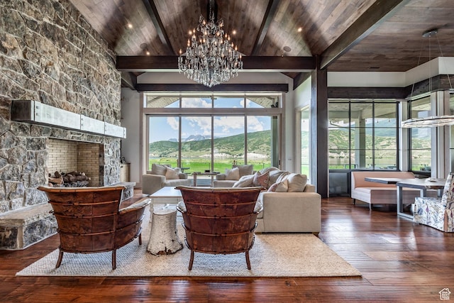 living area with hardwood / wood-style floors, a chandelier, wooden ceiling, and a stone fireplace