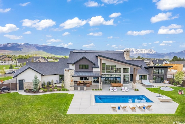 back of house with area for grilling, a lawn, a patio area, and a mountain view