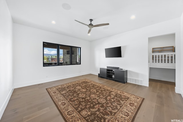 unfurnished living room featuring ceiling fan and dark hardwood / wood-style floors