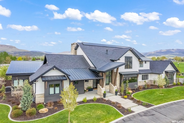 modern farmhouse featuring a mountain view, a front yard, and central air condition unit