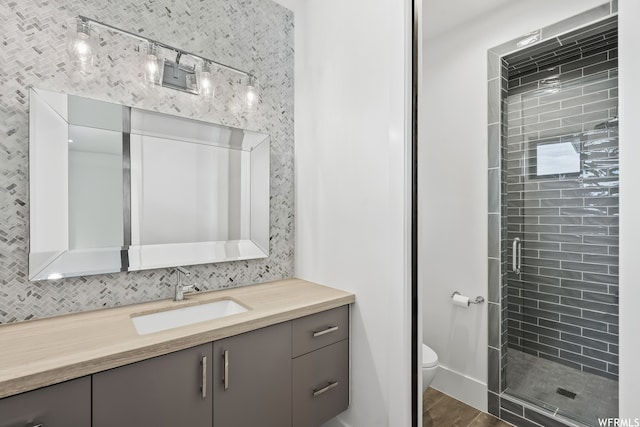 bathroom featuring walk in shower, toilet, vanity, and hardwood / wood-style flooring