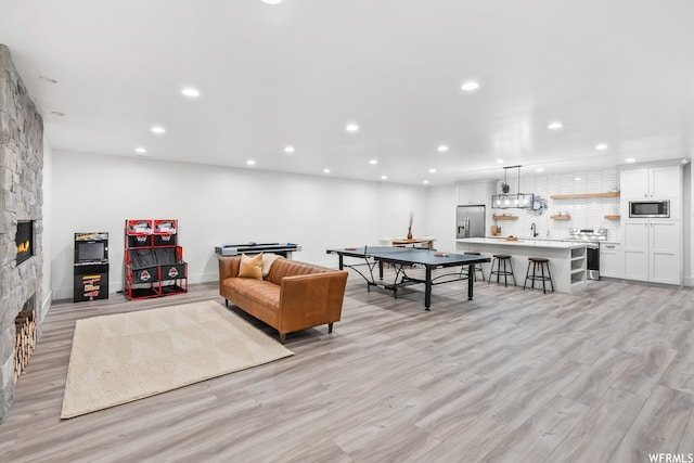 living room featuring light hardwood / wood-style floors, sink, and a fireplace