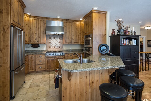 487 Kiva Dr, Moab, UT 84532 - kitchen with sink, appliances with stainless steel finishes, backsplash, a breakfast bar area, and wall chimney range hood