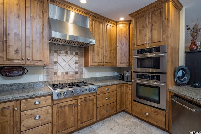 487 Kiva Dr, Moab, UT 84532 - kitchen featuring stainless steel appliances, backsplash, wall chimney range hood, and light tile floors