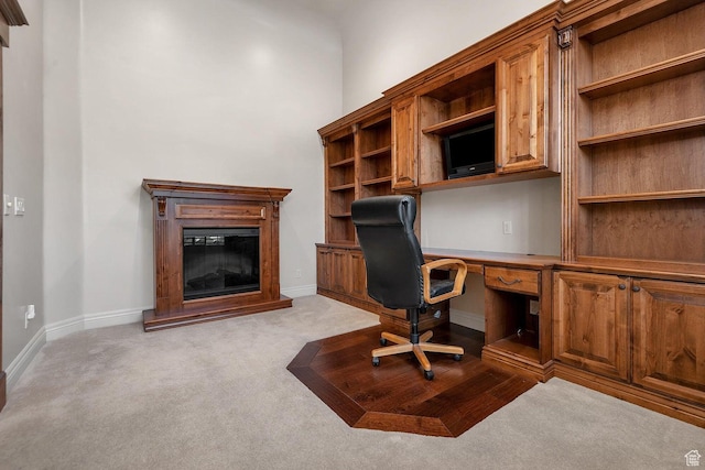 unfurnished office with built in desk and light colored carpet