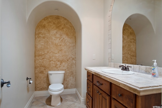 bathroom with tile patterned flooring, vanity, and toilet