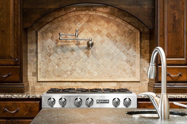 interior details with sink, dark brown cabinetry, stone counters, and stainless steel gas stovetop