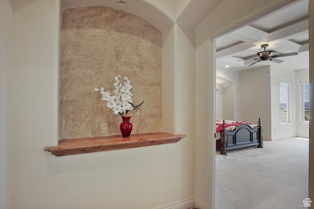 hallway featuring coffered ceiling, light carpet, and beam ceiling