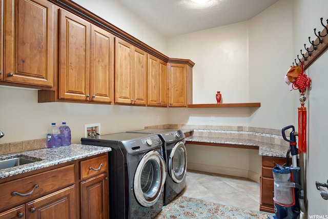 laundry room with washer and dryer, cabinets, sink, and light tile patterned floors