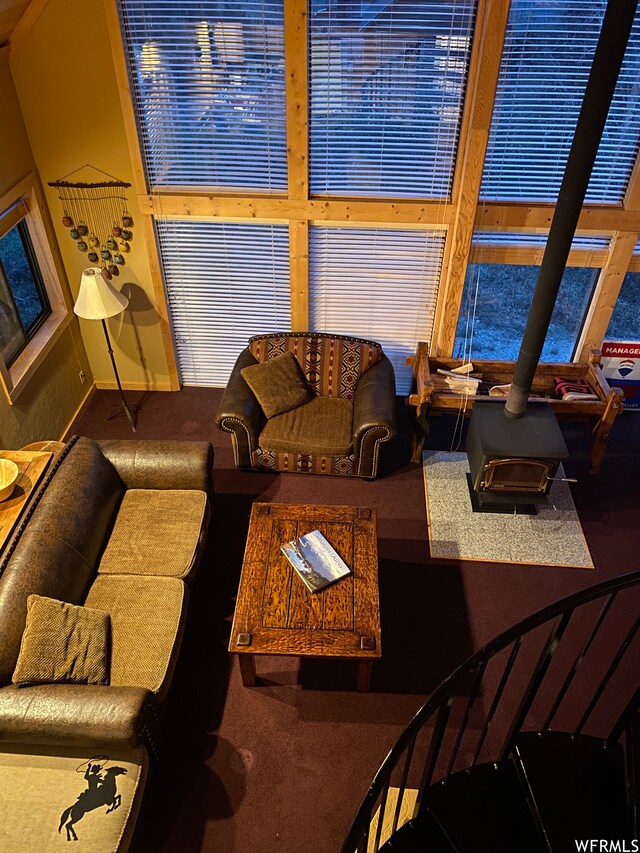 carpeted living room with a wood stove