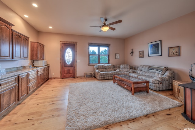 living room with ceiling fan and light hardwood / wood-style flooring