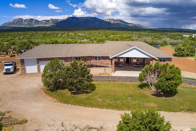 view of front of home featuring a front yard, a mountain view, and a garage