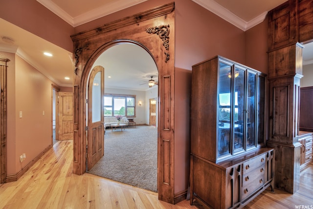 hall featuring ornamental molding, ornate columns, and light hardwood / wood-style flooring