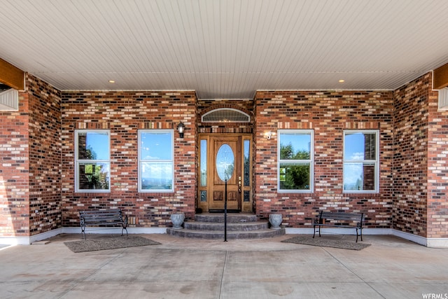 view of exterior entry with a patio area
