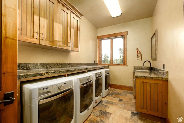 laundry room with cabinet space, washing machine and clothes dryer, light stone finish flooring, and baseboards