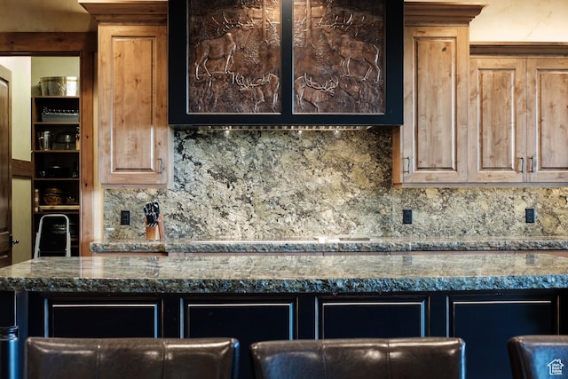 kitchen featuring decorative backsplash and dark countertops