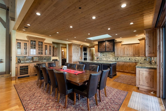 dining area featuring beverage cooler, wood ceiling, recessed lighting, light wood-type flooring, and a skylight