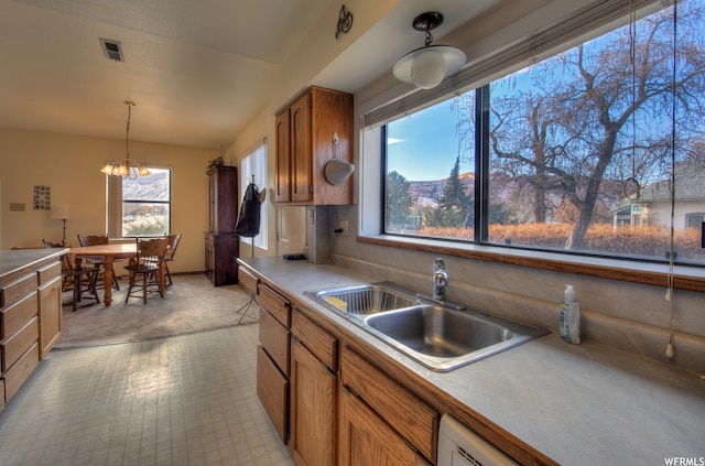 195 E 200 N, Moab, UT 84532 - kitchen with brown cabinets, hanging light fixtures, a chandelier, light countertops, and dishwasher