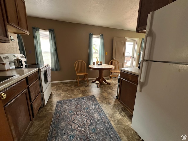 195 E 200 N, Moab, UT 84532 - kitchen with white appliances, a textured ceiling, dark brown cabinets, and light countertops