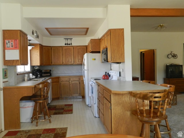 195 E 200 N, Moab, UT 84532 - kitchen with white range with electric cooktop, a peninsula, black microwave, a breakfast bar area, and brown cabinets