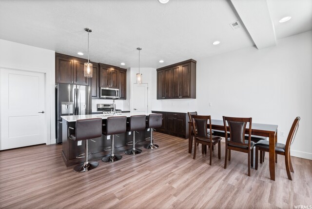 1960 W Jaydin Way Unit 2, West Haven, UT 84401 - kitchen with dark brown cabinets, light wood-type flooring, stainless steel appliances, and a kitchen island with sink