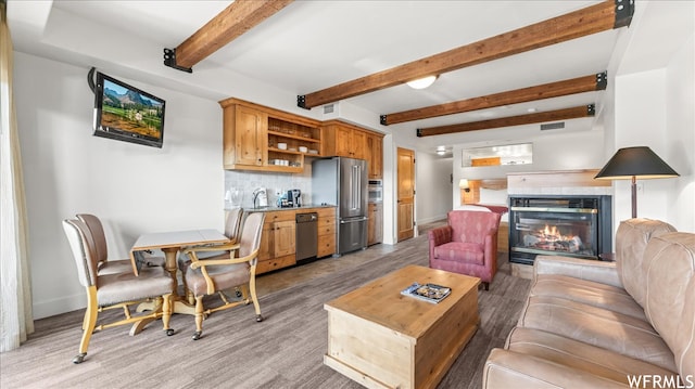 1476 Newpark Blvd Unit 204, Park City, UT 84098 - living room with beamed ceiling, light hardwood / wood-style flooring, sink, and a fireplace