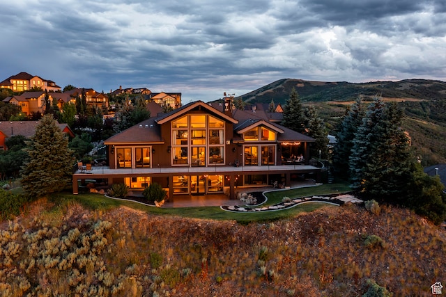 back of house with a mountain view and a patio