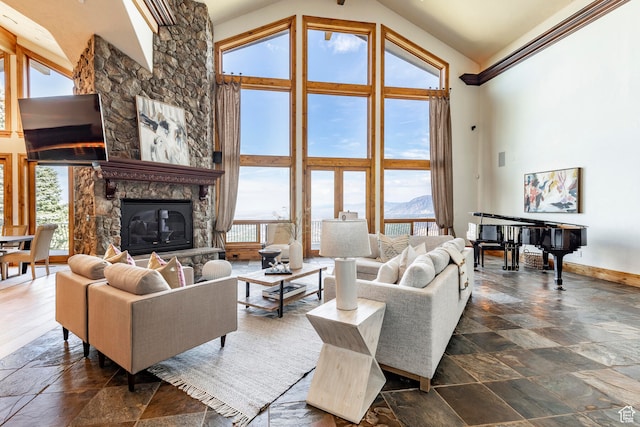 living room with a stone fireplace, high vaulted ceiling, and a wealth of natural light