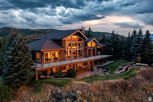 back house at dusk with a patio and a mountain view