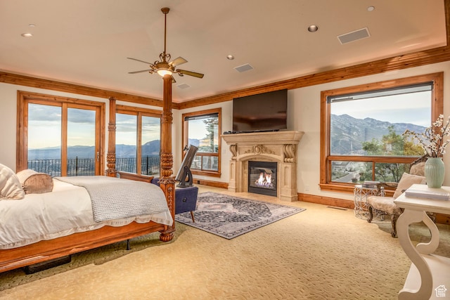 bedroom featuring carpet, ceiling fan, access to outside, and multiple windows