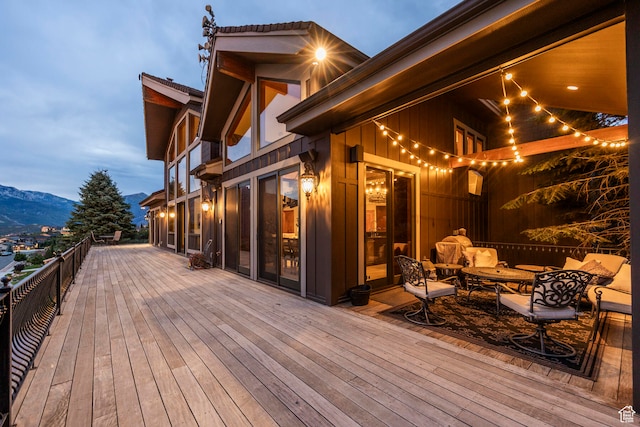 deck at dusk featuring a mountain view and outdoor lounge area