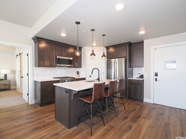 909 W Peace Tree Trl Unit 601, Heber City, UT 84032 - kitchen with dark brown cabinetry, a barn door, stainless steel appliances, and a sink