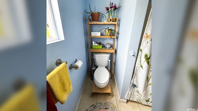 bathroom featuring toilet and tile floors