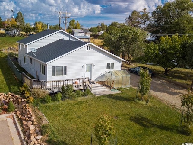 back of house featuring a wooden deck and a yard