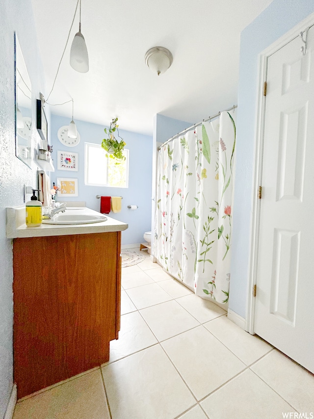 bathroom featuring tile flooring, toilet, and vanity
