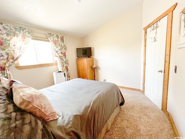 bedroom featuring a closet, light carpet, and lofted ceiling