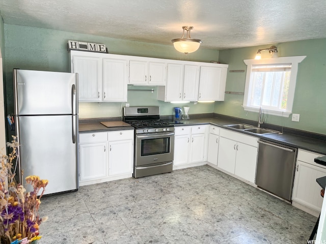 kitchen with light tile floors, white cabinetry, sink, and stainless steel appliances