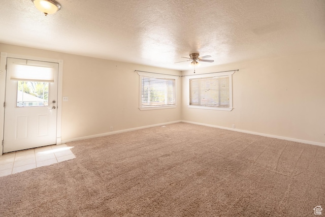 49 E 400 S, Monticello, UT 84535 - empty room with light colored carpet, a ceiling fan, plenty of natural light, a textured ceiling, and baseboards