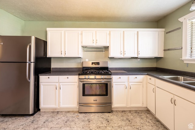 49 E 400 S, Monticello, UT 84535 - kitchen with appliances with stainless steel finishes, dark countertops, a sink, and white cabinets
