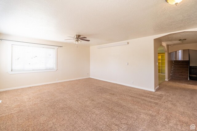 49 E 400 S, Monticello, UT 84535 - empty room with light colored carpet, a ceiling fan, arched walkways, a textured ceiling, and baseboards