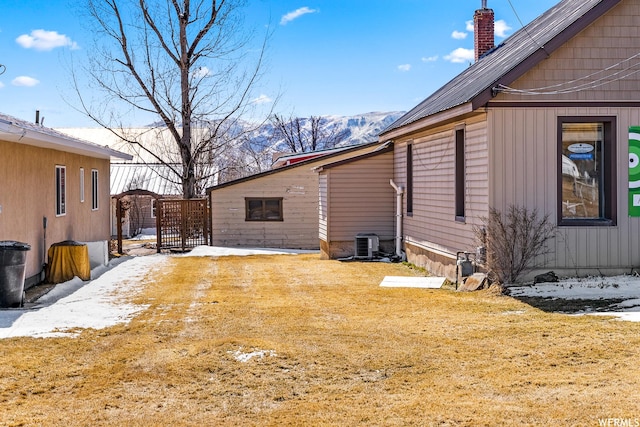 506 E Main St, Midway, UT 84049 - view of snow covered exterior featuring a chimney, central air condition unit, a yard, and a mountain view
