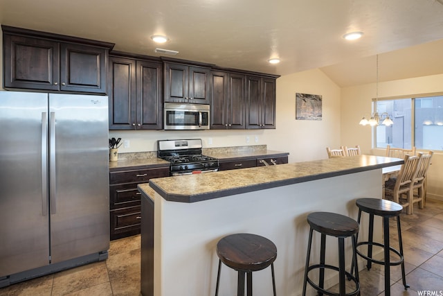 3862 Desert Willow Cir Unit 9-A1, Moab, UT 84532 - kitchen featuring a kitchen bar, dark brown cabinetry, stainless steel appliances, a notable chandelier, and a center island