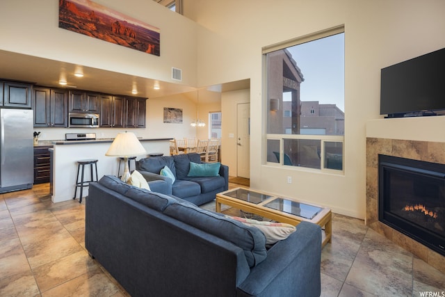 3862 Desert Willow Cir Unit 9-A1, Moab, UT 84532 - living room featuring a high ceiling and a tile fireplace