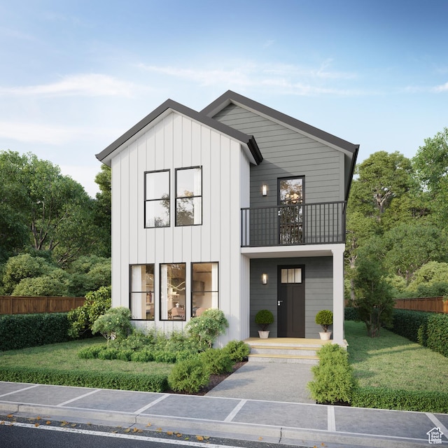 view of front of home with a balcony and a front lawn